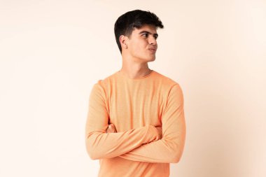 Handsome man over isolated beige background looking to the side