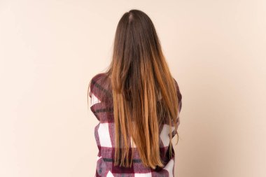 Beyazlı genç bir kadın arka planda bej arka planda izole edilmiş.