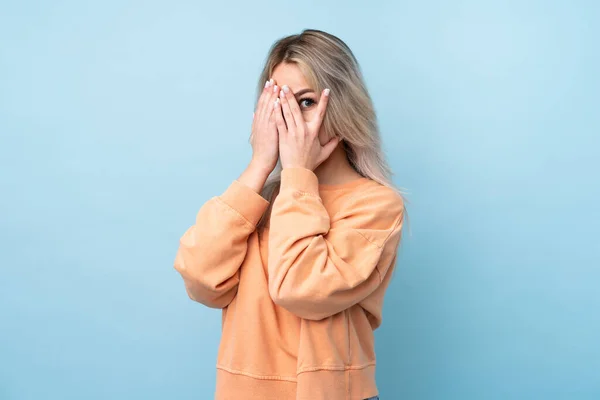 Adolescente Menina Sobre Isolado Fundo Azul Cobrindo Olhos Olhando Através — Fotografia de Stock