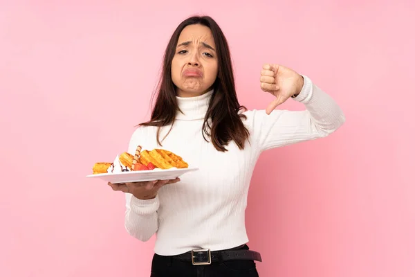 Young Brunette Woman Holding Waffles Isolated Pink Background Showing Thumb — Stock Photo, Image