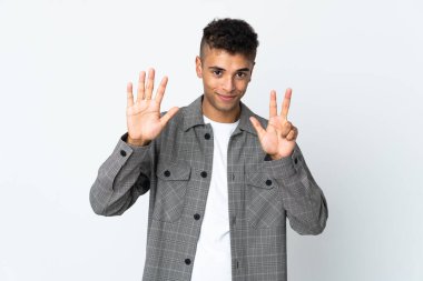 Beyaz arka planda izole edilmiş genç Brezilyalı sekiz parmağıyla sayıyor.