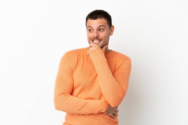 İzole edilmiş beyaz arka planı olan Brezilyalı bir adam yana bakıyor ve gülümsüyor.