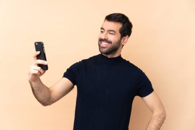 Kafkasyalı yakışıklı adam izole edilmiş arka planda özçekim yapıyor.