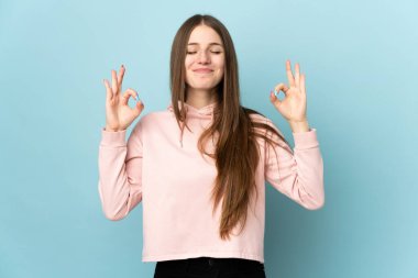 Zen pozunda mavi arka planda izole edilmiş beyaz bir kadın.