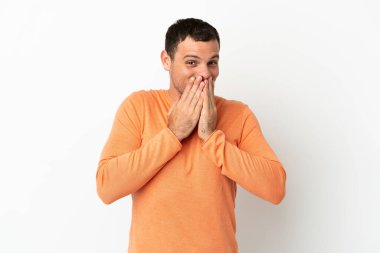 İzole edilmiş beyaz arka plan üzerinde Brezilyalı bir adam mutlu ve gülümsüyor elleriyle ağzını kapatıyor.