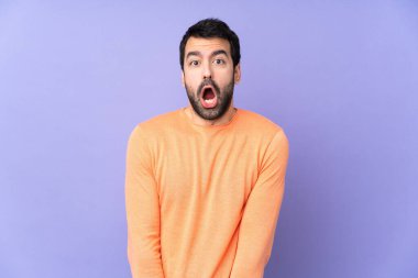 Kafkasyalı yakışıklı bir adam, yalıtılmış mor bir geçmişi var ve yüzünde sürpriz bir ifade var.