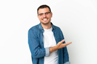 İzole edilmiş beyaz arka planda Brezilyalı bir adam gülümseyerek bir fikir sunuyor.