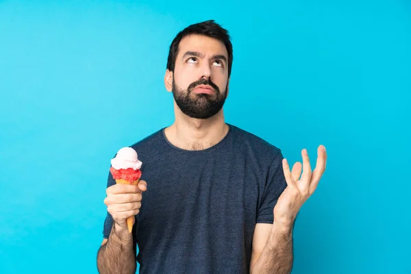 Junger Mann Mit Einem Kornetteis Vor Isoliertem Blauen Hintergrund Frustriert — Stockfoto