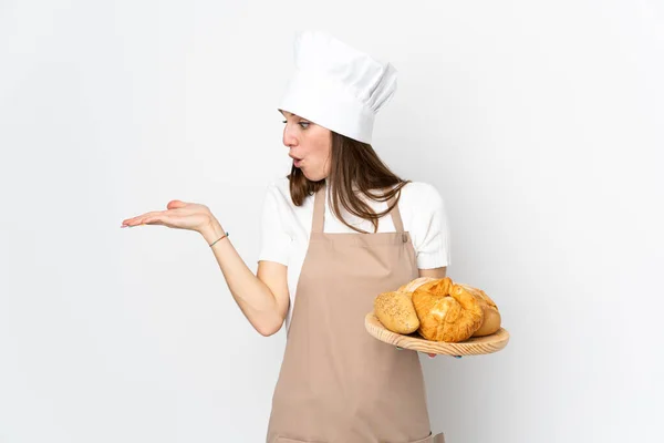 穿着厨师制服的年轻女子被隔离在白色背景中 手掌上还带着想象的复制空间 — 图库照片