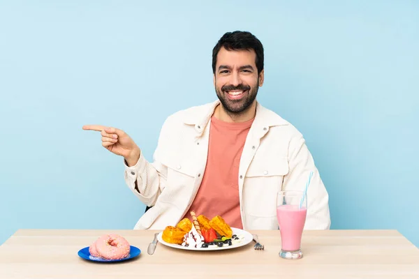 Man Vid Ett Bord Med Frukostvåfflor Och Milkshake Pekar Finger — Stockfoto