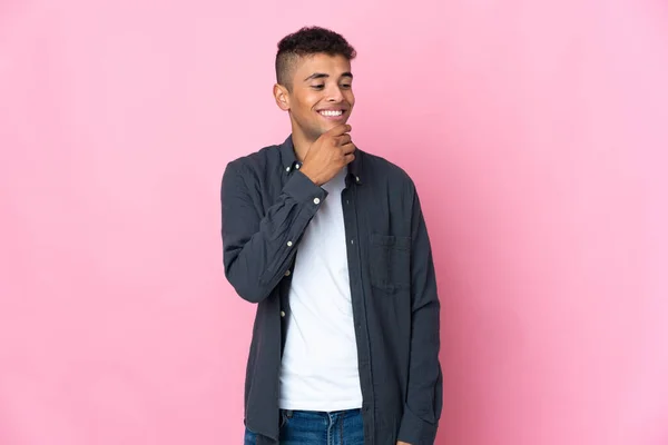 Jonge Braziliaanse Man Geïsoleerd Roze Achtergrond Kijken Naar Zijkant Glimlachen — Stockfoto
