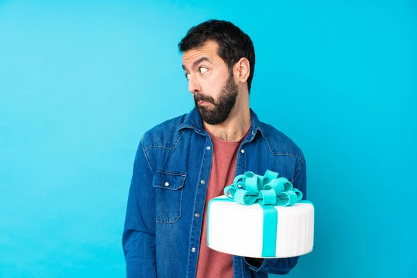 Joven Hombre Guapo Con Una Gran Torta Sobre Fondo Azul —  Fotos de Stock