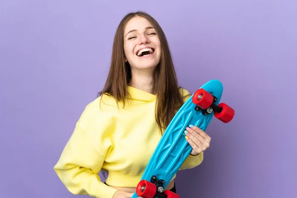 若いです白人女性は幸せな表情でスケートで紫の背景に隔離されました — ストック写真
