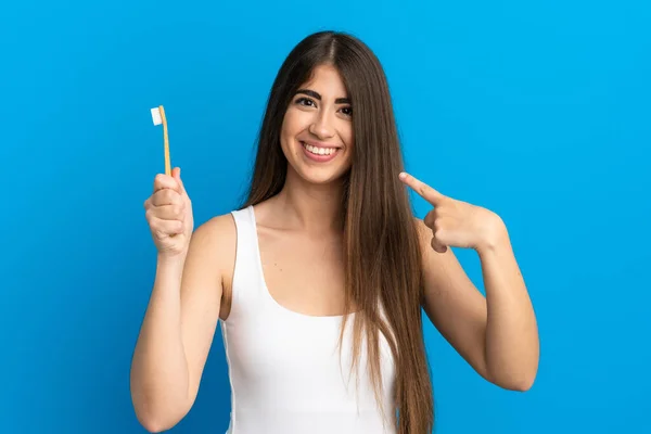 Jonge Blanke Vrouw Poetsen Tanden Geïsoleerd Blauwe Achtergrond Geven Een — Stockfoto