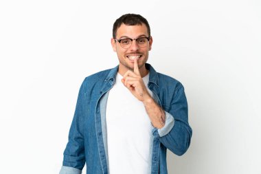 İzole edilmiş beyaz arka plan üzerinde Brezilyalı bir adam sessizlik işareti gösteriyor. Parmağını ağzına sokuyor.