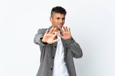 Beyaz arka planda izole edilmiş genç Brezilyalı adam sinirleri öne doğru geriliyor.