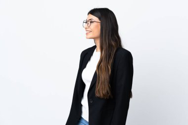 İzole edilmiş beyaz arka planda iş kadını yan tarafa bakıyor.