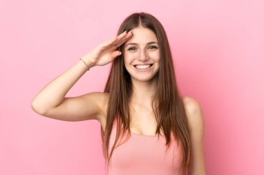 Pembe arka planda izole edilmiş beyaz bir kadın. Mutlu bir ifadeyle selamlıyor.