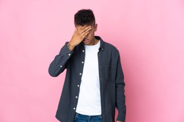 Pembe arka planda başağrısı olan Brezilyalı genç bir adam.