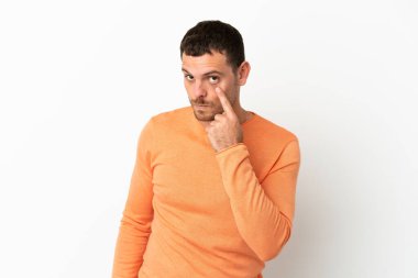 İzole edilmiş beyaz arka planda Brezilyalı bir adam bir şey gösteriyor