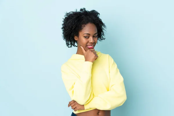 Jovem Afro Americana Isolada Fundo Azul Olhando Para Lado Sorrindo — Fotografia de Stock