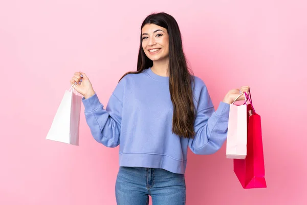 Jong Brunette Meisje Geïsoleerde Roze Achtergrond Holding Shopping Tassen Glimlachen — Stockfoto