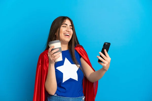 Super Héroe Mujer Caucásica Aislada Sobre Fondo Azul Sosteniendo Café —  Fotos de Stock