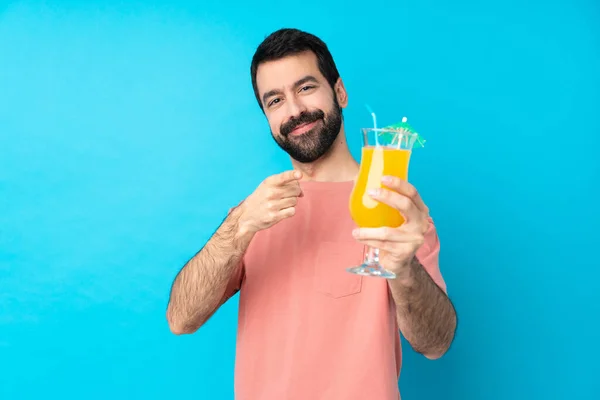 Junger Mann Hält Einen Cocktail Vor Isoliertem Blauen Hintergrund — Stockfoto