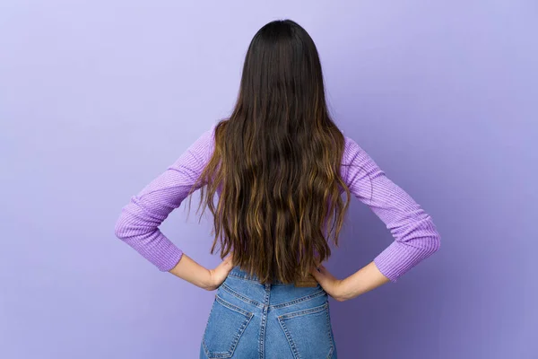 年轻的黑发女子背向孤立的紫色背景 — 图库照片