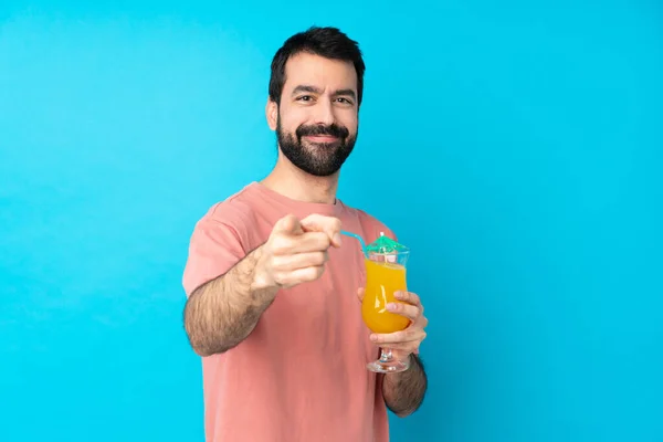 Joven Sosteniendo Cóctel Sobre Fondo Azul Aislado Señala Con Dedo — Foto de Stock