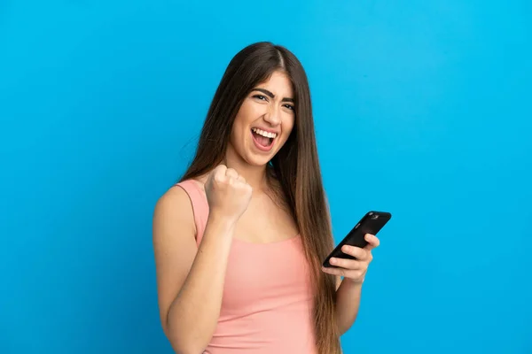 Mujer Joven Caucásica Aislada Sobre Fondo Azul Con Teléfono Posición —  Fotos de Stock