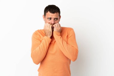 İzole edilmiş beyaz arka planda Brezilyalı bir adam gergin ve korkmuş bir şekilde elleriyle suni teneffüs yapıyor.