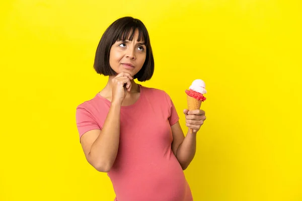 Беременная Женщина Держит Корнет Мороженое Изолированы Желтом Фоне Глядя Вверх — стоковое фото