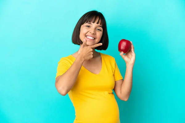 Schwangere Mit Einem Apfel Auf Blauem Hintergrund Glücklich Und Lächelnd — Stockfoto