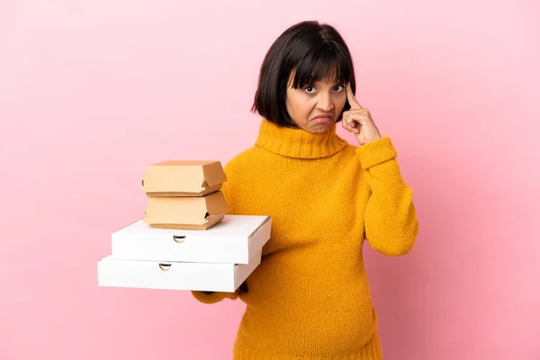 Mulher Grávida Segurando Pizzas Hambúrgueres Isolados Fundo Rosa Pensando Uma — Fotografia de Stock