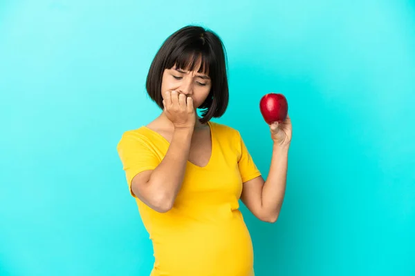 Schwangere Mit Einem Apfel Auf Blauem Hintergrund Hat Zweifel — Stockfoto