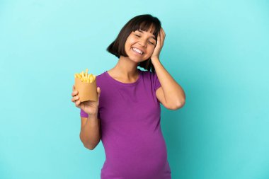 Kızarmış cipsleri izole edilmiş arka planda tutan hamile kadın çok gülümsüyor.