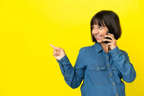 Mujer Embarazada Usando Teléfono Móvil Aislado Sobre Fondo Amarillo Apuntando —  Fotos de Stock