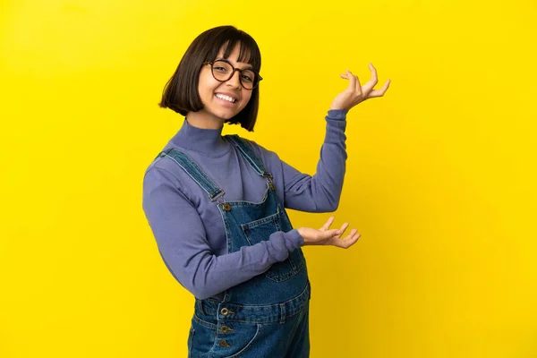 Jovem Grávida Sobre Fundo Amarelo Isolado Estendendo Mãos Para Lado — Fotografia de Stock