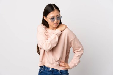 Genç Çinli bir kız, omuz ağrısından muzdarip, izole edilmiş beyaz bir altyapıya sahip.