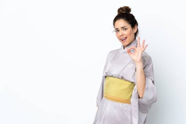 İzole edilmiş arkaplanda kimono giyen kadın parmaklarıyla işaret veriyor.