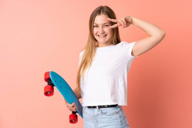 Genç Ukraynalı kaykaycı kız pembe arka planda mutlu bir ifadeyle izole edilmiş.