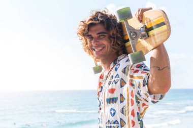 Genç beyaz adam sahilde uzun pano çalışması yapıyor.