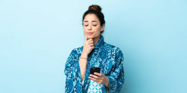 Kimono giyen bir kadın soyutlanmış geçmişi düşünüp mesaj gönderiyor.