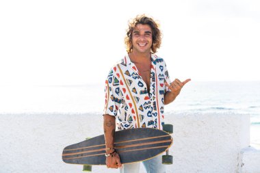 Genç beyaz adam sahilde uzun pano çalışması yapıyor.