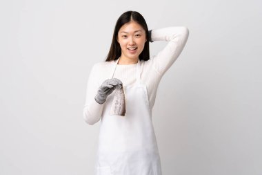 Çinli balıkçı önlük takıyor ve soyutlanmış beyaz arka planda çiğ balık tutuyor.