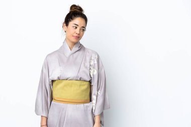 Kimono giyen bir kadın izole edilmiş arka planda kuşkuları var.