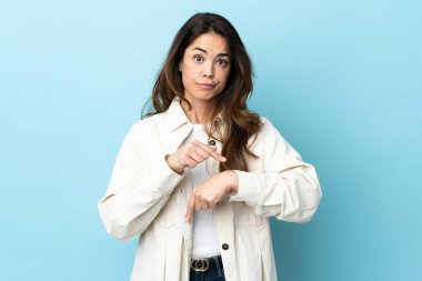 Woman over isolated background making the gesture of being late