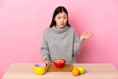 Genç Çinli kız şüpheli hareketler yaparak kahvaltı yapıyor.