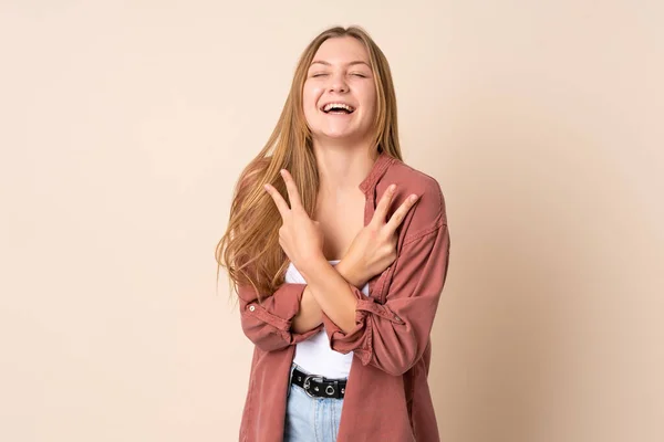Έφηβη Ουκρανή Κοπέλα Απομονωμένη Μπεζ Φόντο Χαμογελώντας Και Δείχνοντας Σύμβολο — Φωτογραφία Αρχείου